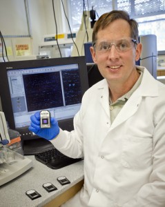 Gary Andersen, Berkeley Lab microbial ecologist, holding a PhyloChip that can detect the presence of 50,000 different species of bacteria and archaea in a single sample from any environmental source. (Photo by Roy Kaltschmidt, Berkeley Lab)