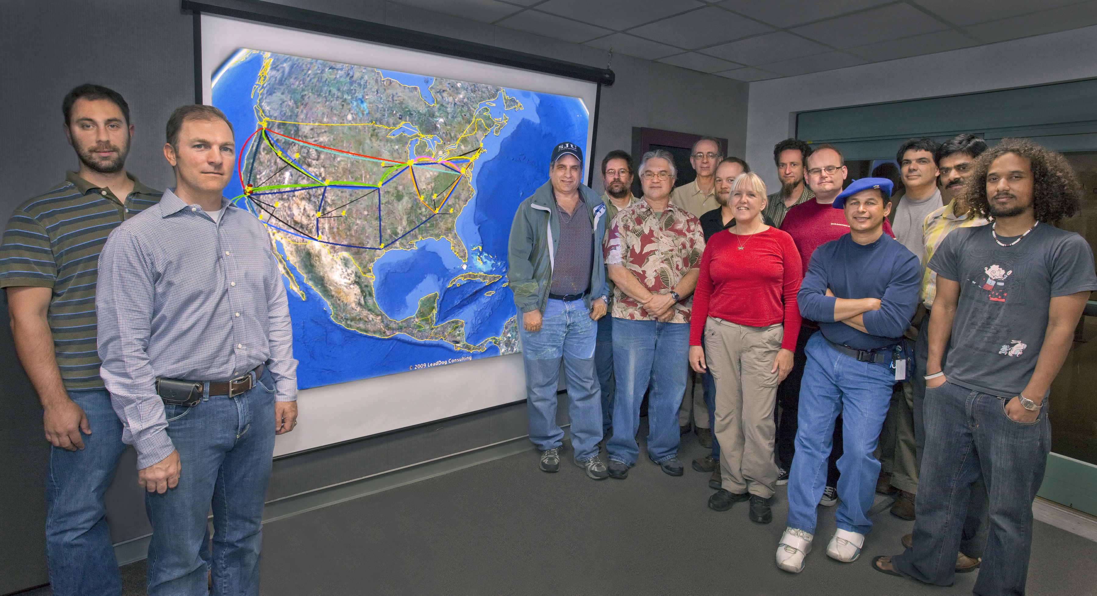 ESnet Department Head Steve Cotter (second from left), shown here with the ESnet team and a map of the high-performance computer network they manage, will oversee development of a prototype 100 Gbps network.