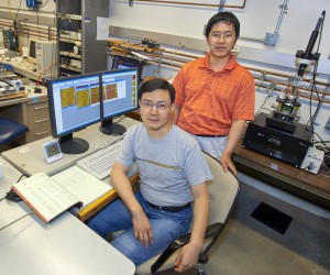 Junqiao Wu (sitting)led a team that included Jinbo Cao (Standing) which demonstrated that phase inhomogeneity in correlated electron materials can be created through the application of external strain. (Photo by Roy Kaltschmidt, Berkeley Lab Public Affairs)