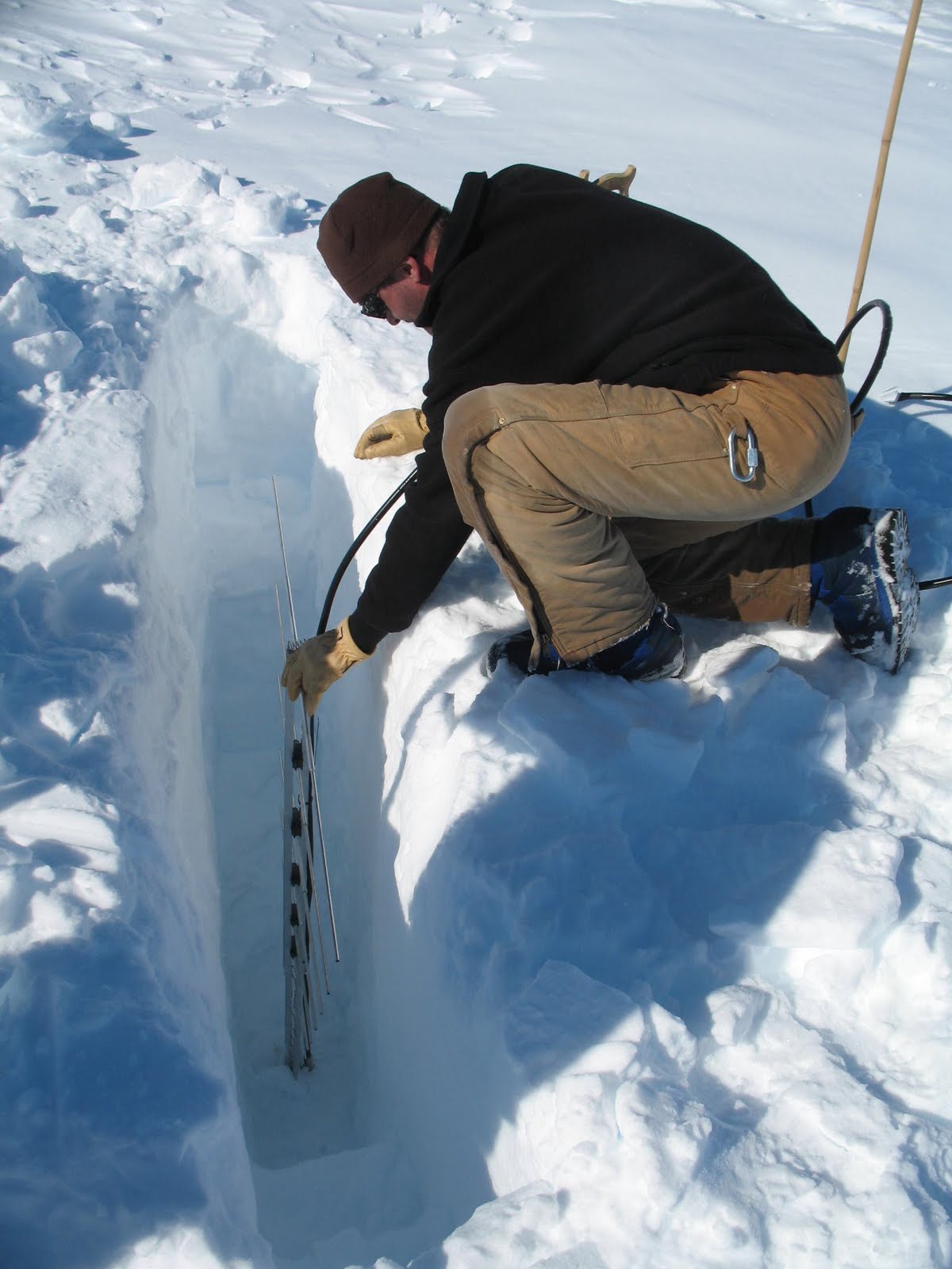 Thorsten Stezelberger buries a radio antenna six feet deep in the snow. 