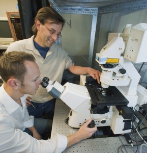 Guillaume Sandoz (seated) and Ehud Isacoff developed a unique fluorescent assay technique that enabled them to the  TREK1, a protein that could be a target for antidepressants. (Photo by Roy Kaltschmidt, Berkeley Lab Public Affairs)