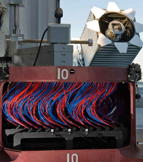 For each 15-minute exposure of a small region of the sky, technicians plug a thousand optical fibers by hand into a plate that fits at the focal plane of the 2.5-meter Sloan Telescope. Each fiber feeds the light of an individual galaxy to BOSS’s advanced spectrogram. 