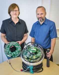 Lisa Gerhardt and Spencer Klein with an IceCube Digital Optical Module (DOM). IceCube employs 5,160 DOMs to detect the Cherenkov radiation emitted by high-energy neutrino events in the ice. (Photo by Roy Kaltschmidt)
