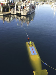 During the 2015 mission to survey the ex-USS Independence CVL 22, the Office of National Marine Sanctuaries' research vessel Fulmar served as the escort boat for Boeing’s Autonomous Underwater Vehicle (AUV) Echo Ranger. The 67-foot aluminum catamaran research vessel’s crew is preparing to tow Echo Ranger to sea. Credit: Robert V. Schwemmer, NOAA