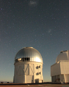 The Víctor M. Blanco Telescope at the Cerro Tololo Inter-American Observatory in Chile, where the Dark Energy Camera is being used to collect image data for the DECam Legacy Survey. The glint off the dome is moonlight; the small and large Magellanic clouds can be seen in the background. (Image: Dustin Lang, University of Toronto)