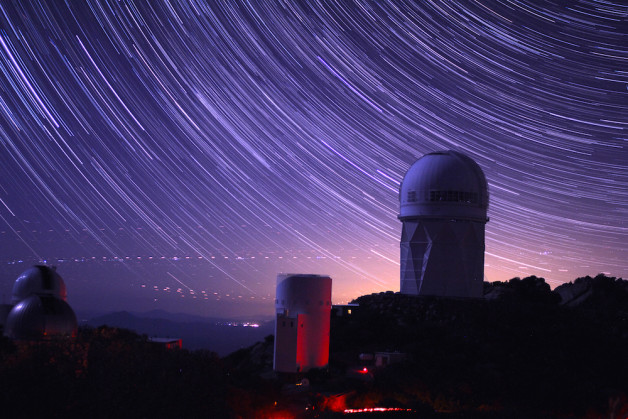 Star trails take shape around Kitt Peak National Observatory in this long-exposure image. The 4-meter Mayall telescope building, at right, now houses Mosaic-3, a new infrared camera built by a collaboration that includes Berkeley Lab scientists. (Photo credit: P. Marenfeld and NOAO/AURA/NSF)