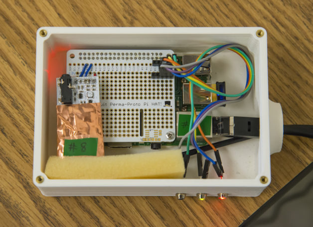Photo - A DoseNet device consists of a 3-D-printed case, a Raspberry Pi computer circuit board (upper left), a small radiation sensor (coated in copper foil at lower left), and an Internet connection (at right). (Credit: Roy Kaltschmidt/Berkeley Lab)