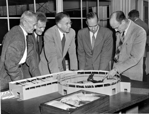 Photo - From left to right: Donald Cooksey, Harold Fidler, Professor Ernest Orlando Lawrence, William Brobeck, and Ed Lofgren inspect a scale model of the Bevatron. (Credit: Berkeley Lab)