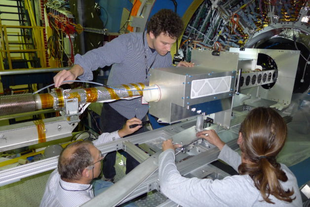Image - The Heavy Flavor Tracker during insertion into the STAR detector. Pictured at bottom left is Howard Wieman, the designer of the HFT. (Credit: Leo Greiner/Berkeley Lab)
