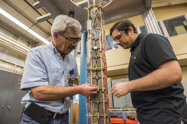 Image - Ahmet Pekedis, left, and Diego Arbelaez inspect the completed niobium tin undulator prototype. (Credit: Marilyn Chung/Berkeley Lab)