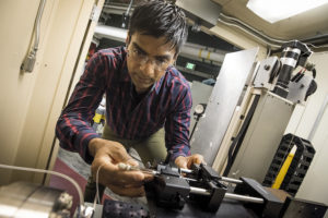 Photo - Sayan Gupta inserts a sample holder at an X-ray footprinting beamline at Berkeley Lab's Advanced Light Source. (Credit: Paul Mueller)