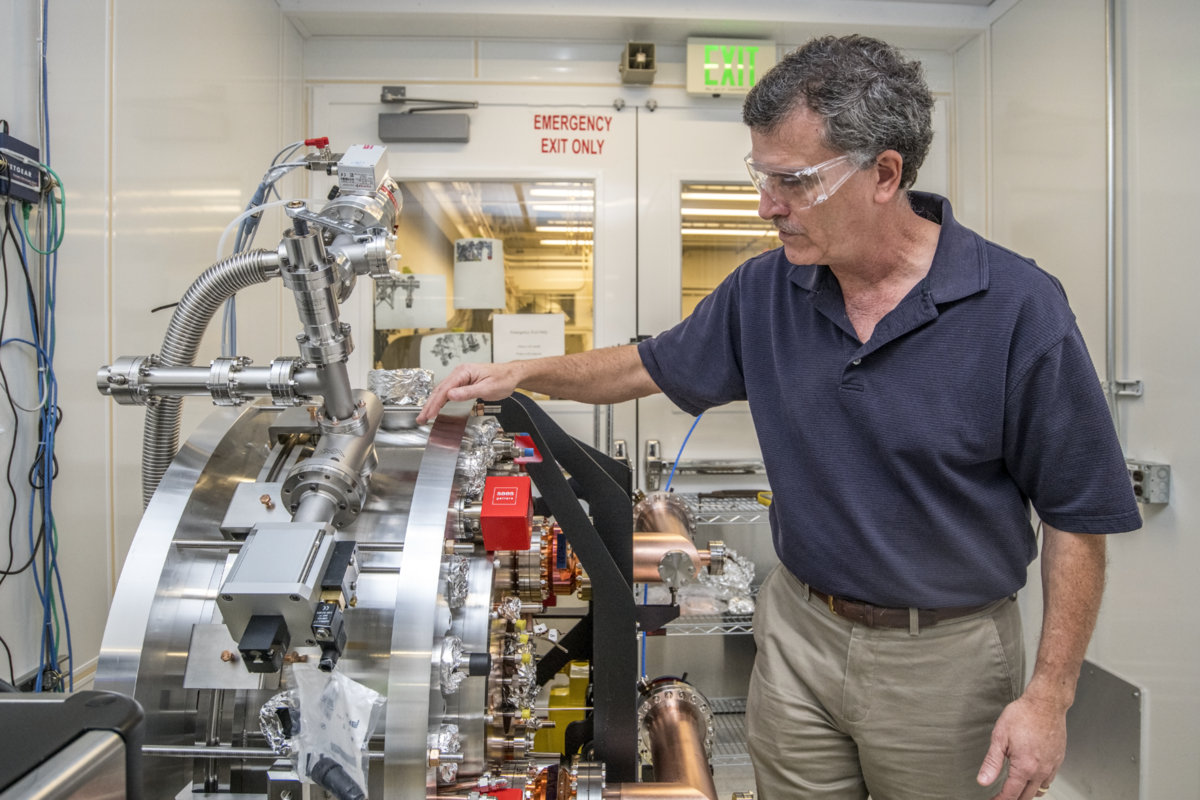 Photo - Steve Virostek, a senior engineer who led the injector gun's construction, inspects the mounted injector prior to shipment. (Credit: Marilyn Chung/Berkeley Lab)