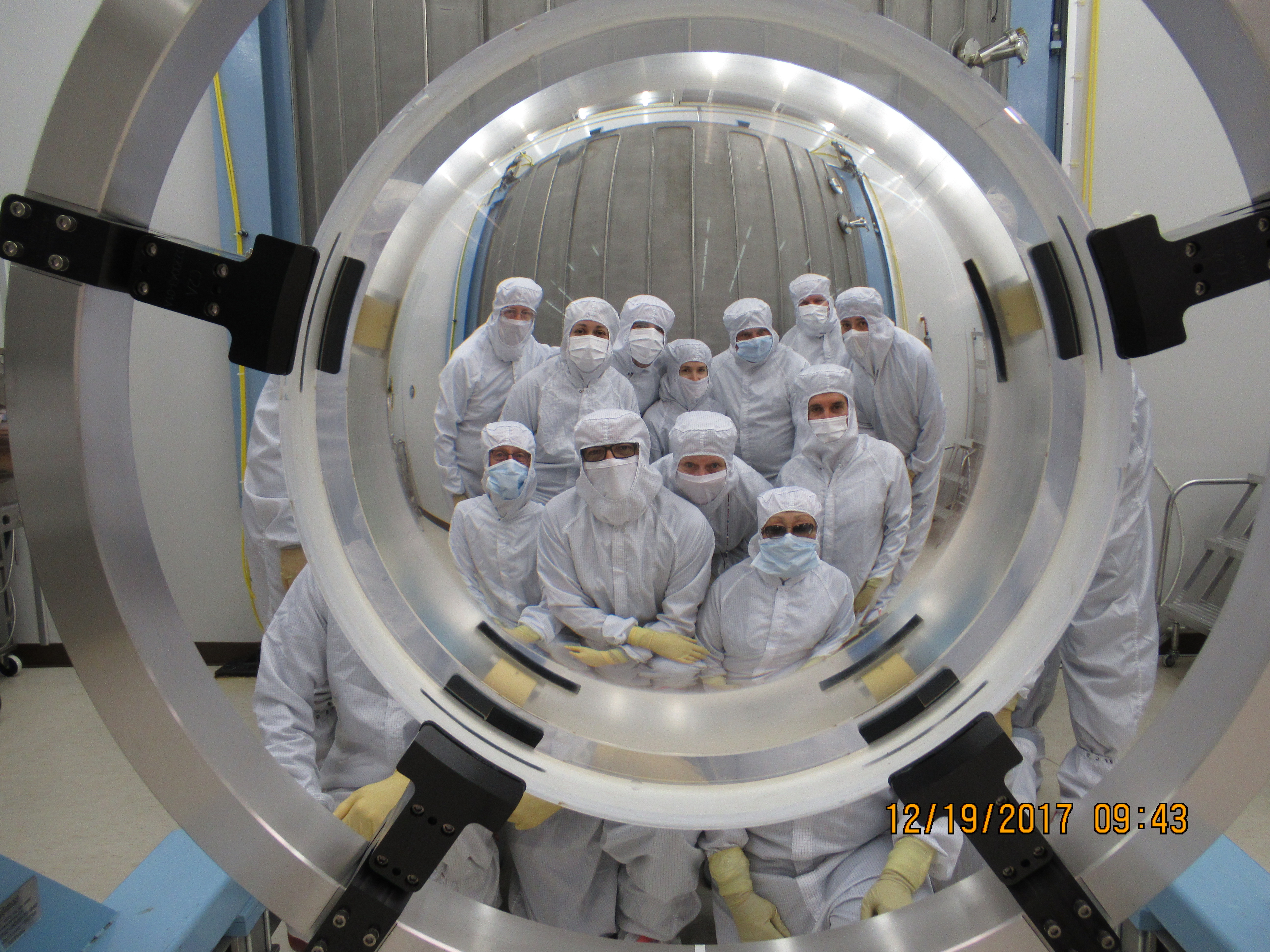 Photo - A team at Viavi Solutions in Santa Rosa, Calif., poses behind the lens after applying an antireflective coating.