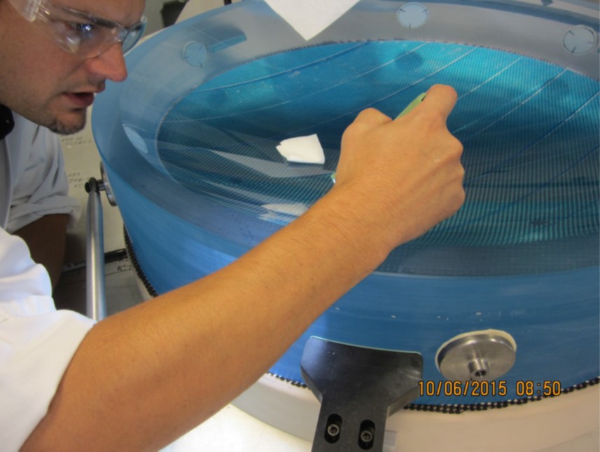 Photo - The lens is inspected for damage during a polishing process at Arizona Optical Systems (AOS) in Tucson, Ariz.