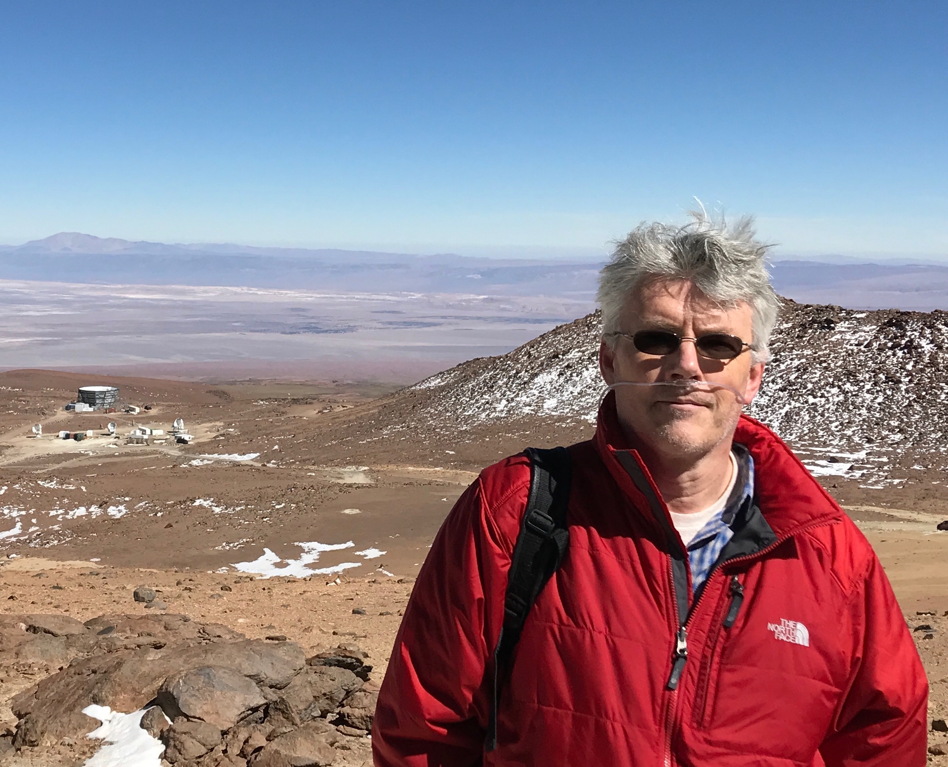 Photo - Julian Borrill in Chile's Atacama Desert with the POLABEAR and ACT telescopes in the background. (Photo courtesy of Julian Borrill/Berkeley Lab)