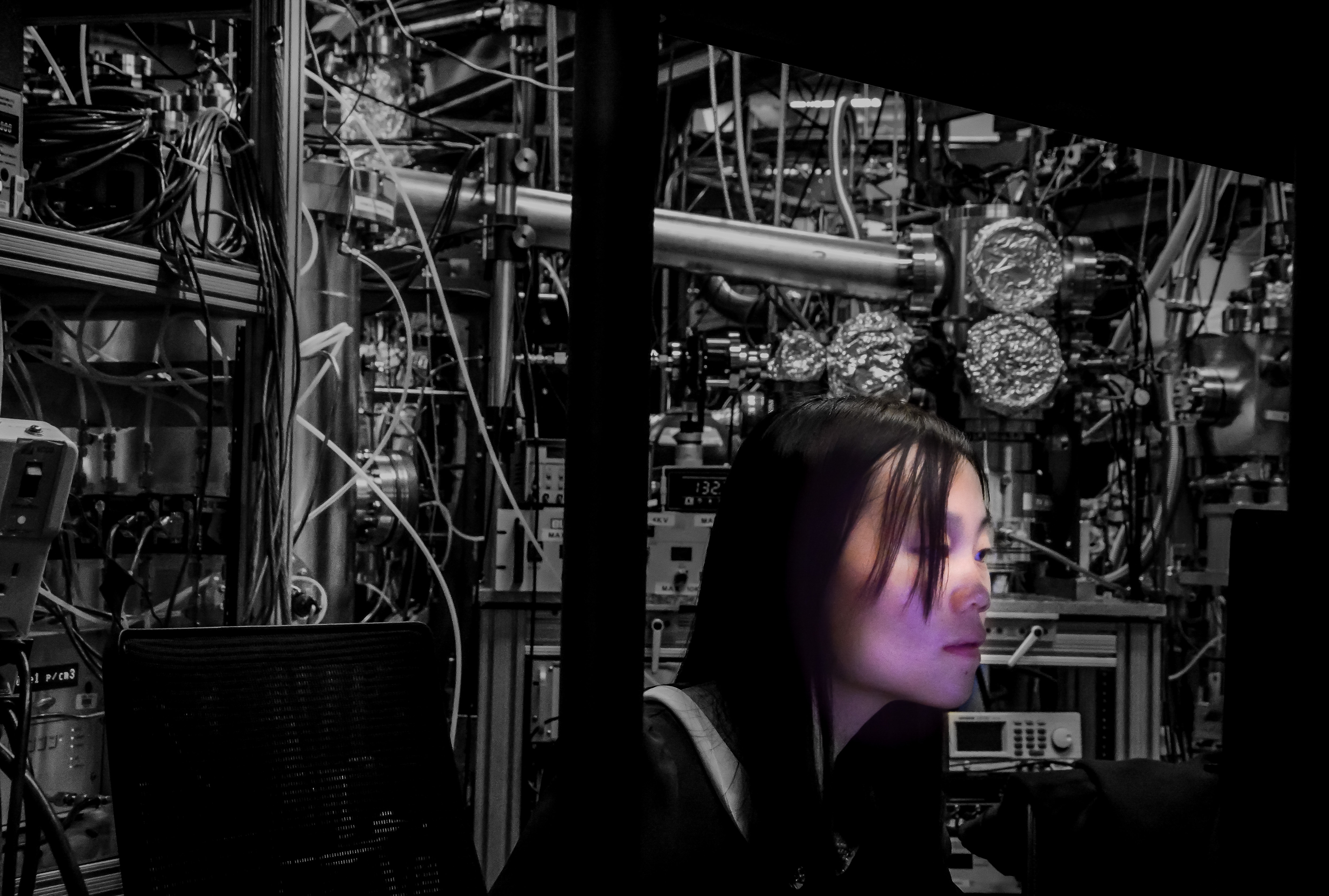 Photo - "ALS Scientist." Mixed black-and-white and color. Meirong Zeng, a Lab postdoctoral researcher, works at ALS Beamline 9.0.2, which specializes in chemical dynamics. (Credit: Michael Dawson)