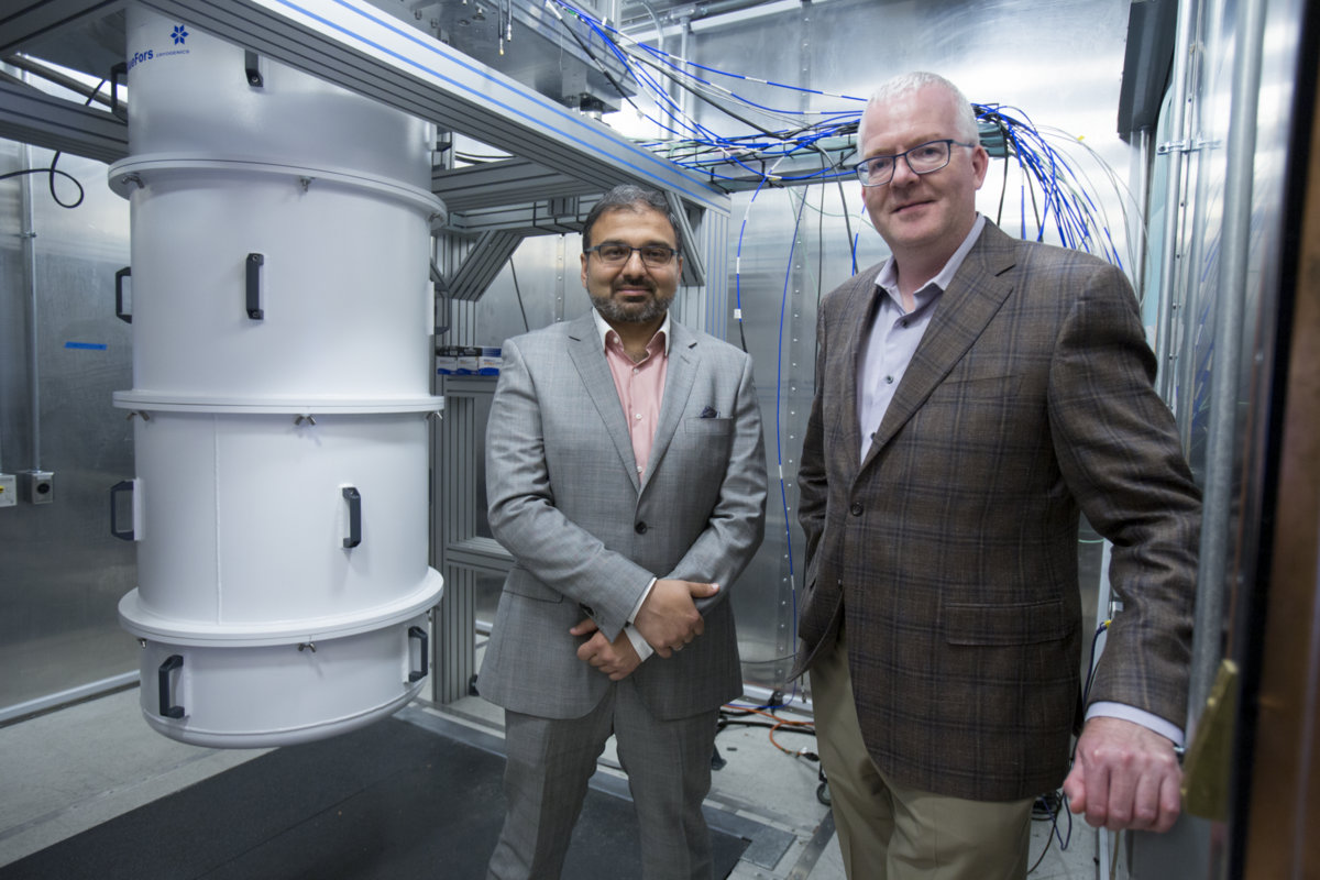 Photo - Irfan Siddiqi (left), director of the Lab’s AQT effort, and Jonathan Carter, AQT co-principal investigator, in front of a dilution refrigerator housing superconducting qubits. Siddiqi is a staff scientist in Berkeley Lab's Material Sciences Division and Carter is the deputy of science for Berkeley Lab's Computing Sciences Area. (Credit: Peter DaSilva, Berkeley Lab)