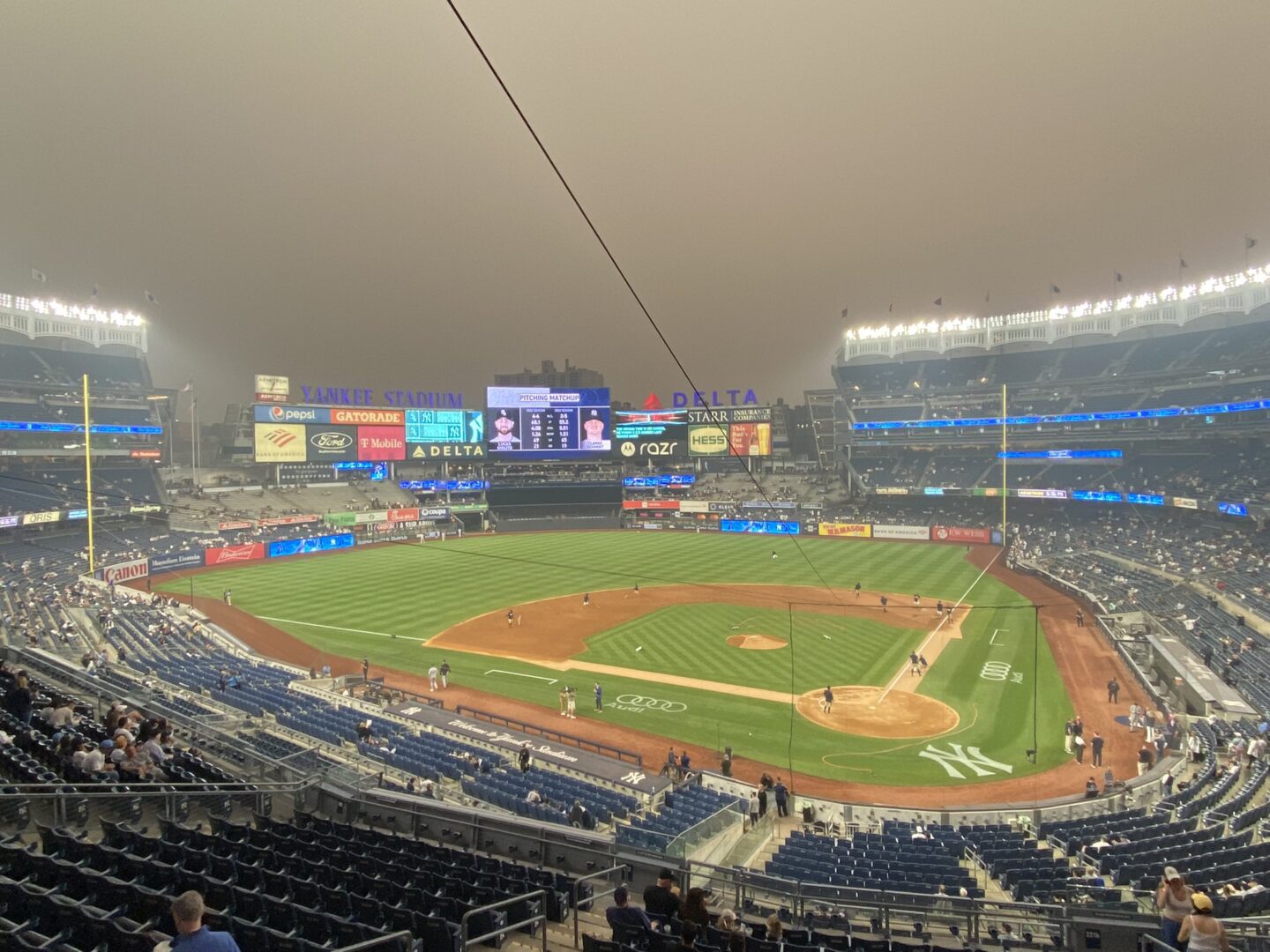 View of a baseball field from the stands with smoky air.