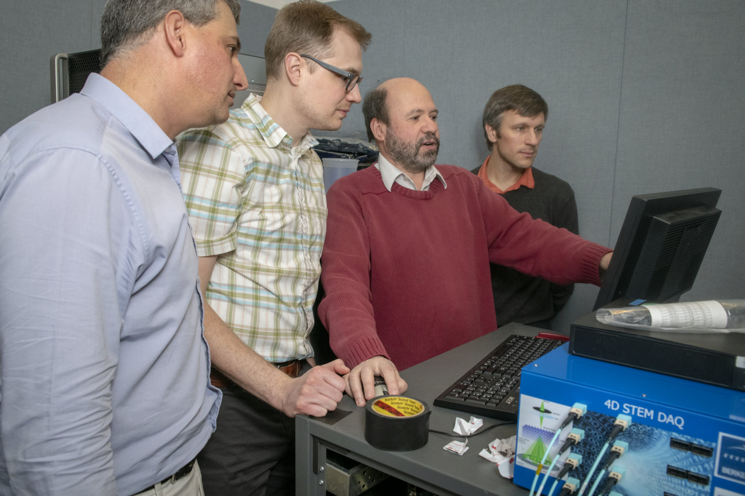 Photo - From left to right: Berkeley Lab’s Ian Johnson, Jim Ciston, Peter Denes, and Peter Ercius work on troubleshooting for a new, superfast detector, the 4D Camera, installed at the TEAM 0.5 microscope at Berkeley Lab’s Molecular Foundry. (Credit: Thor Swift/Berkeley Lab)