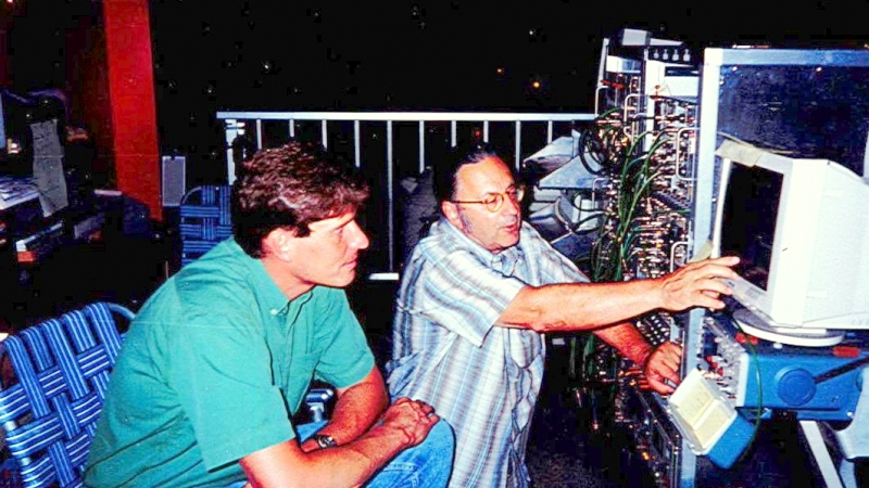 Photo - In this 1990s photo, Alan Smith (right) discusses data recorded at the Oroville facility – where a dark matter and neutrinoless double-beta decay experiment was housed – with Dave Martinez, key account manager for AMETEK ORTEC. (Credit: Berkeley Lab)