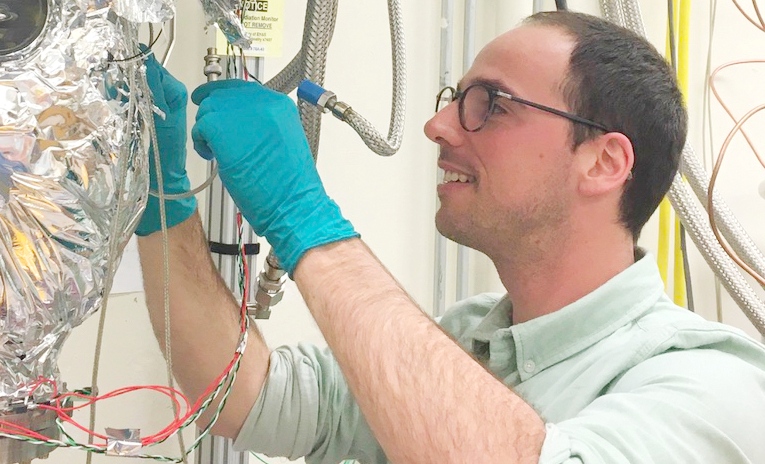 Photo - Quentin Riffard works on wiring for the Xenon Breakdown Apparatus (XeBrA), a detector that is designed to study how high voltages affect noble liquids relevant to dark matter searches. (Credit: XeBrA Collaboration)