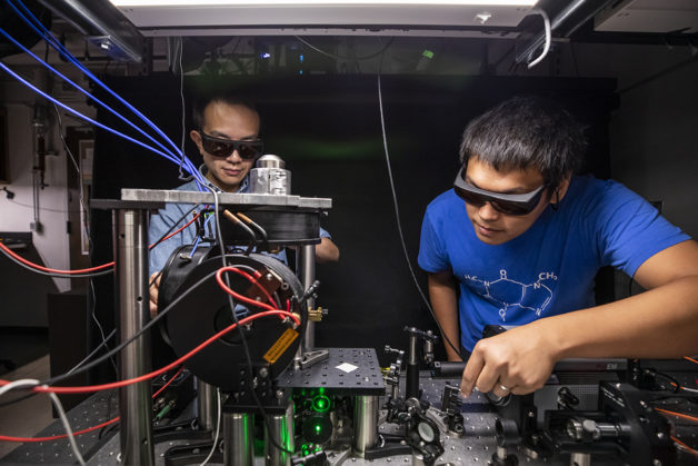 Co-lead authors Satcher Hsieh (left) and Chong Zu tune the laser of their imaging system. When excited by laser light, NV centers emit photons whose brightness informs researchers about the local environment that they are sensing. 