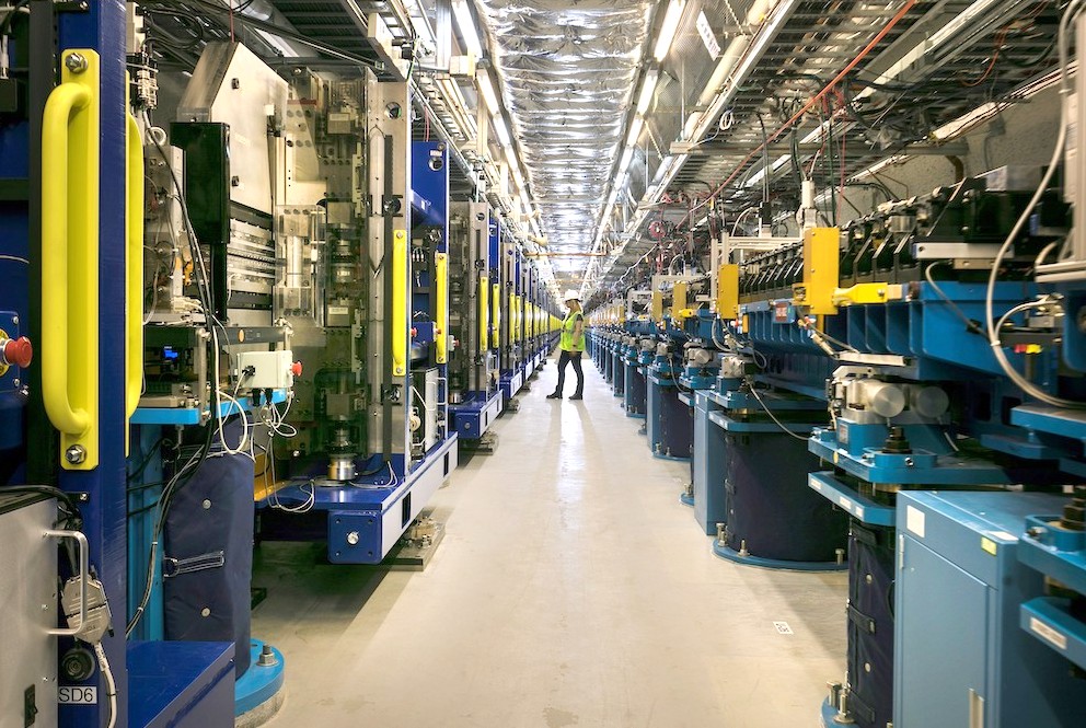 Photo - A worker inspects the soft X-ray undulator at SLAC National Accelerator Laboratory. The hard X-ray undulator is visible at right. (Credit: SLAC National Accelerator Laboratory)