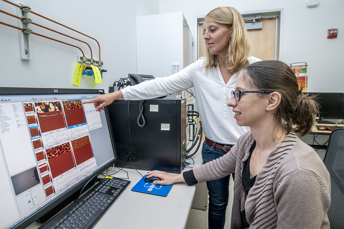 Francesca Toma (right) and Johanna Eichhorn developed a special technique using an atomic force microscope at Berkeley Lab’s JCAP laboratory to capture images of thin-film bismuth vanadate at the nanoscale to understand how a material’s properties can affect its performance in an artificial photosynthesis device. (Credit: Marilyn Sargent/Berkeley Lab)