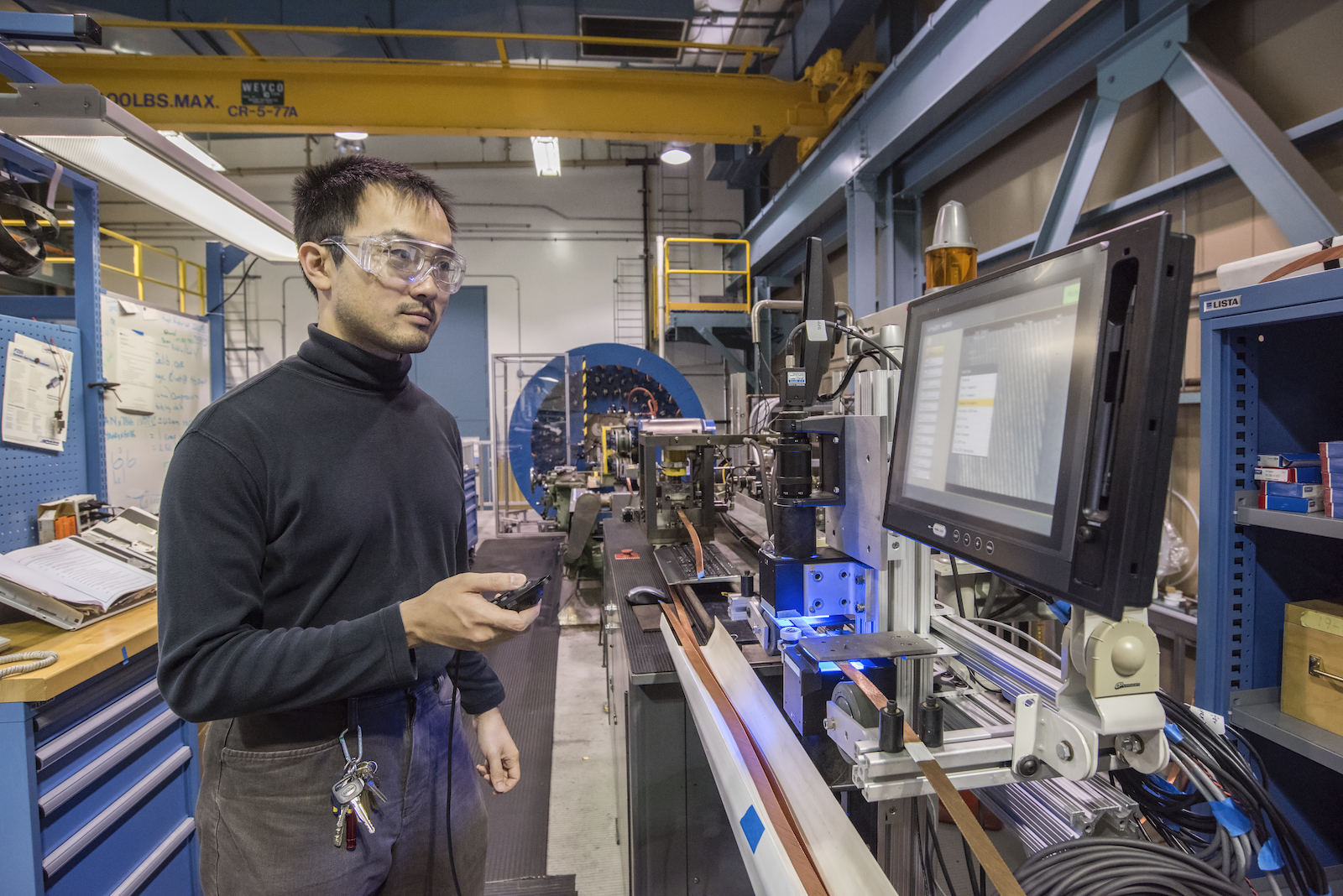 Photo - Ian Pong, materials project scientist and lab cable task leader, inspects a cable in this 2016 photo. (Credit: Marilyn Sargent/Berkeley Lab)