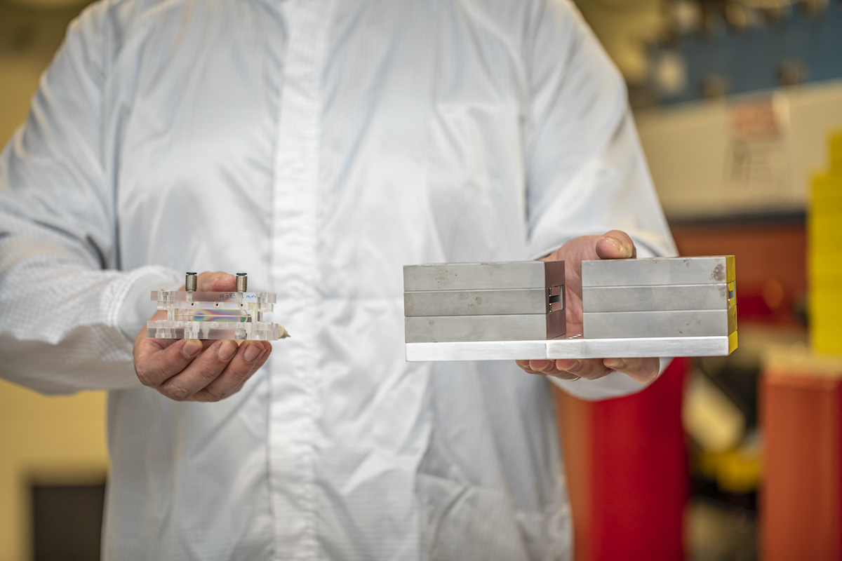 Photo - Sam Barber holds an active plasma lens, left, and dipole magnets used in an electron-beam diagnostic experiment at the BELLA Center. (Credit: Marilyn Sargent/Lawrence Berkeley National Laboratory)