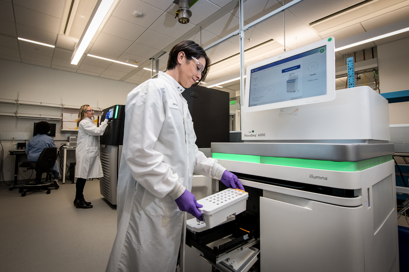 Scientist loads a sample into a gene sequencing platform