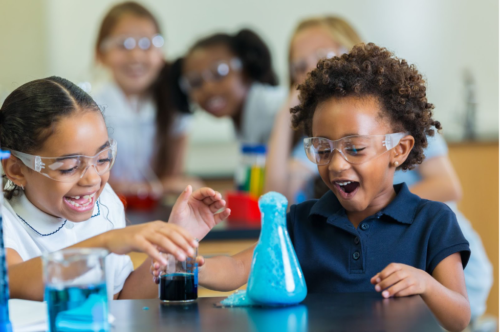 Children laughing while conducting a science experiment.