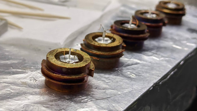 Doped CeCoIn5 samples resting on copper “puck” sample holders.