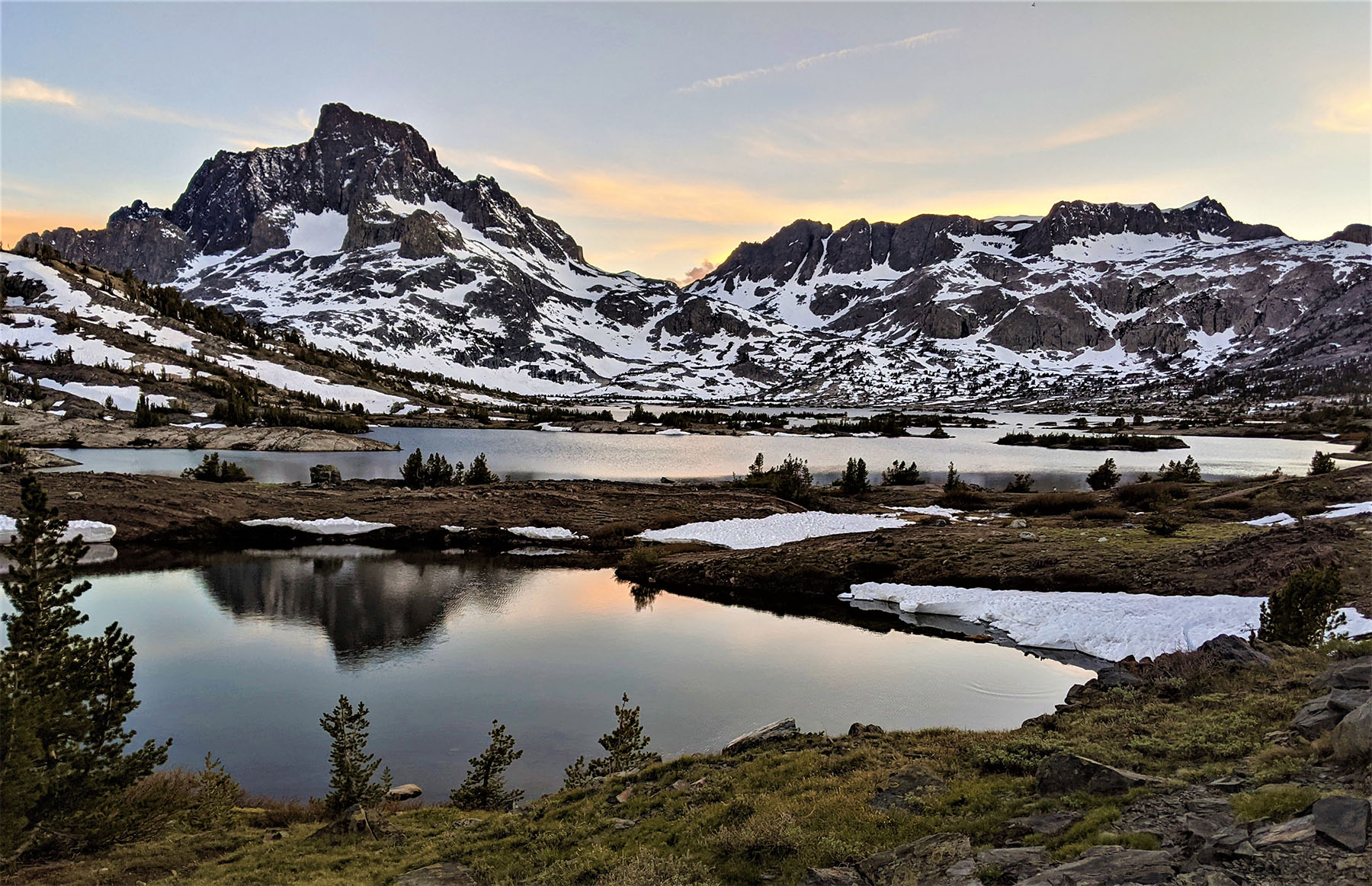 Spring snowmelt in the Ansel Adams Wilderness of the California Sierra Nevada against a setting sky.