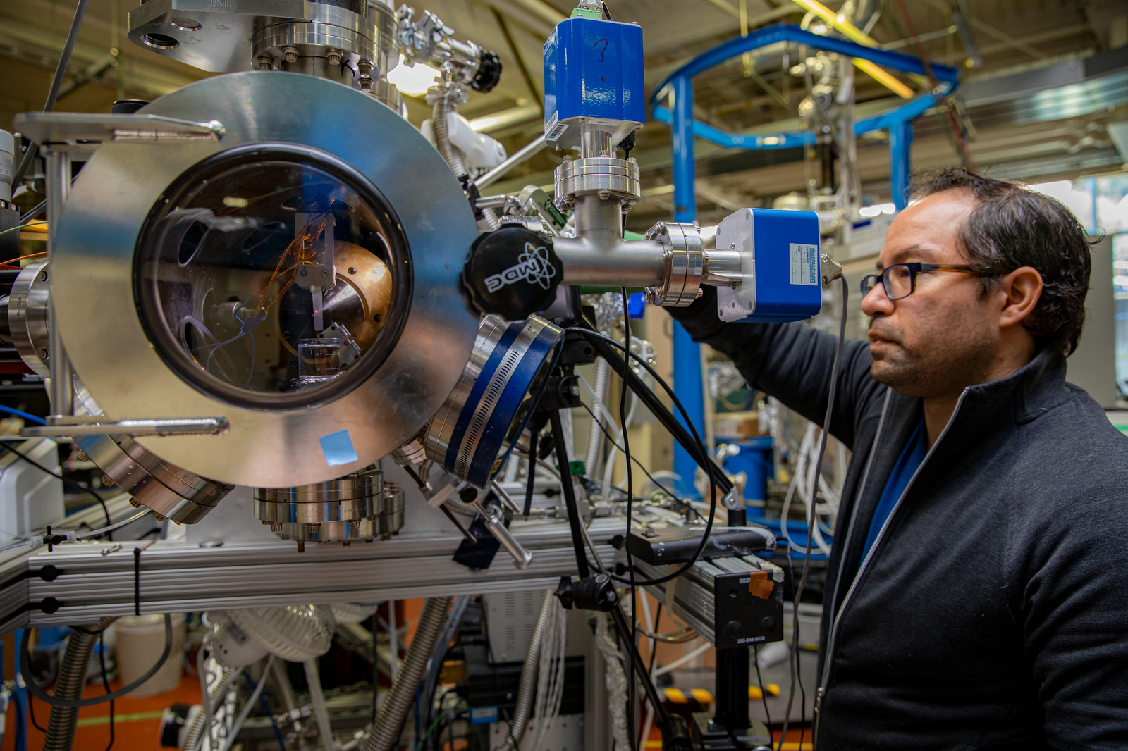 A scientist handles a large scientific instrument in the Advanced Light Source.