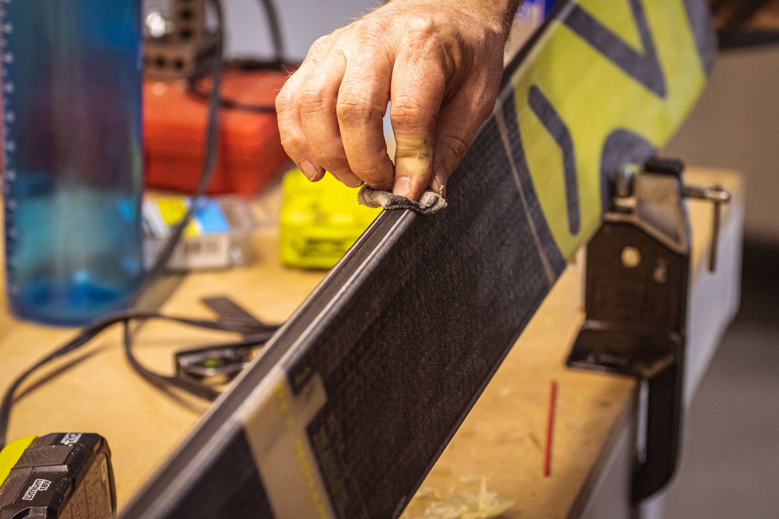 A technician hand smoothing a developing ski.