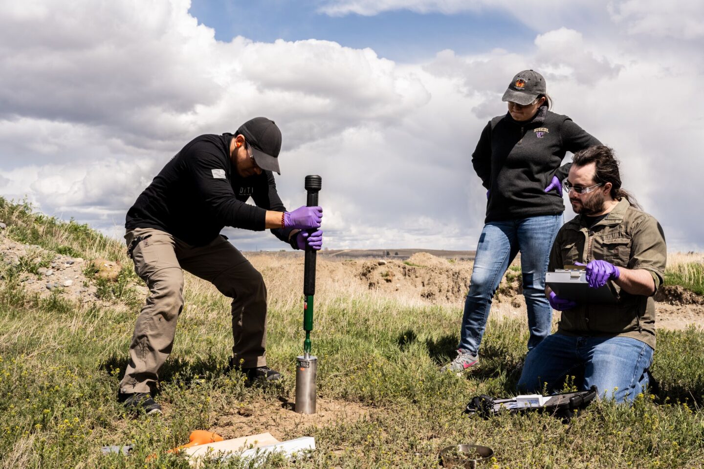 Scientists at Pacific Northwest National Laboratory extract a foot-long soil core for study through the Molecular Observation Network.