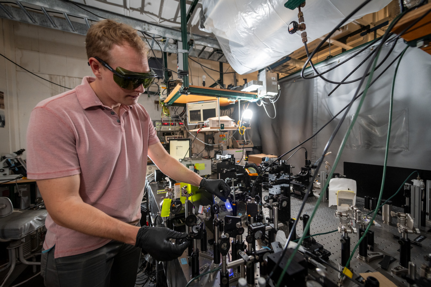 Shane Devlin makes adjustments to the deep UV second harmonic generation spectroscopy device at UC Berkeley.