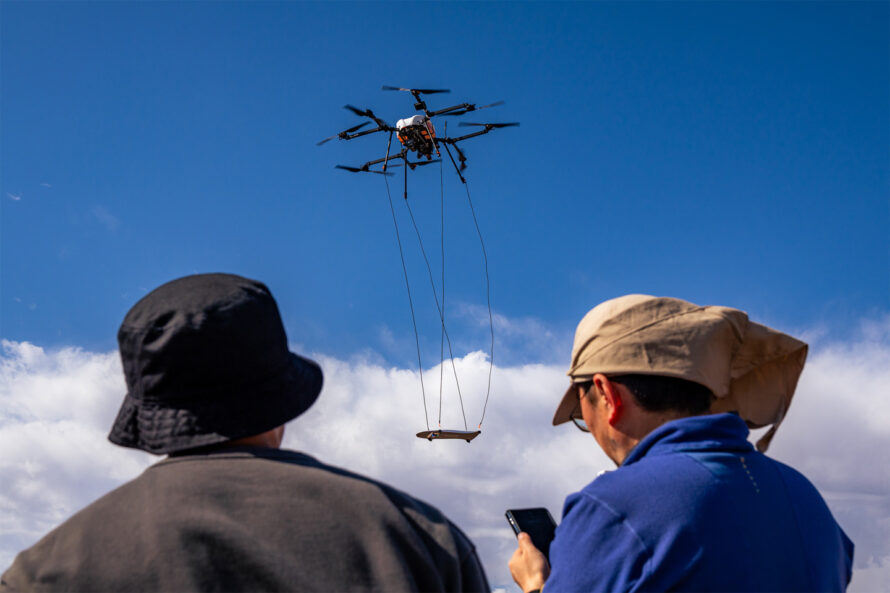 Two people flying a drone outdoors.