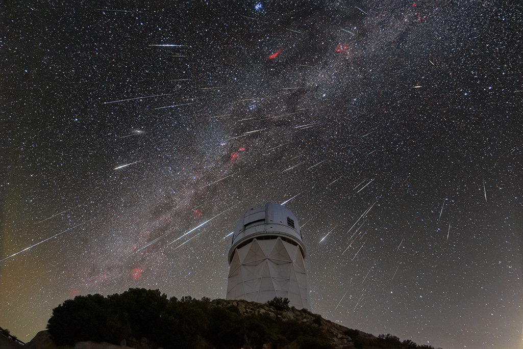 Meteors from the Geminid meteor shower streak across the sky above the Nicholas U. Mayall 4-meter telescope at Kitt Peak National Observatory (KPNO).