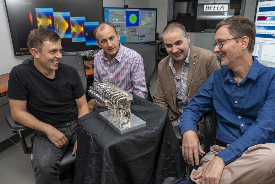 Four members of the BELLA team in an office sitting in chairs around the new gas injector system.