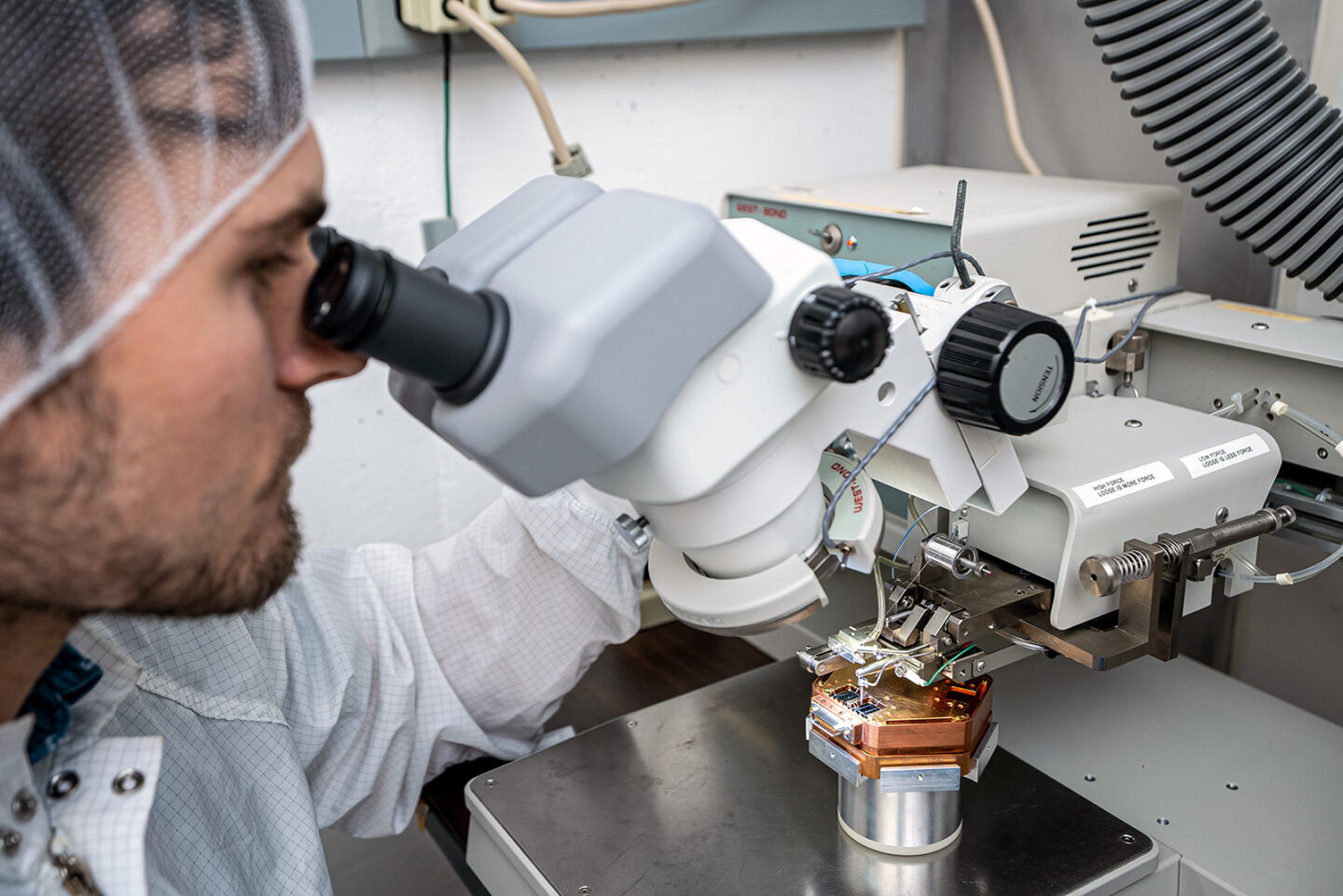 A researcher peers into a microscope.