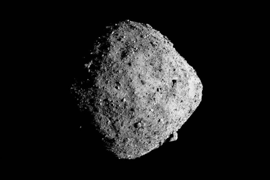 Roughly diamond-shaped asteroid with a rocky, uneven surface, set against a completely black background.