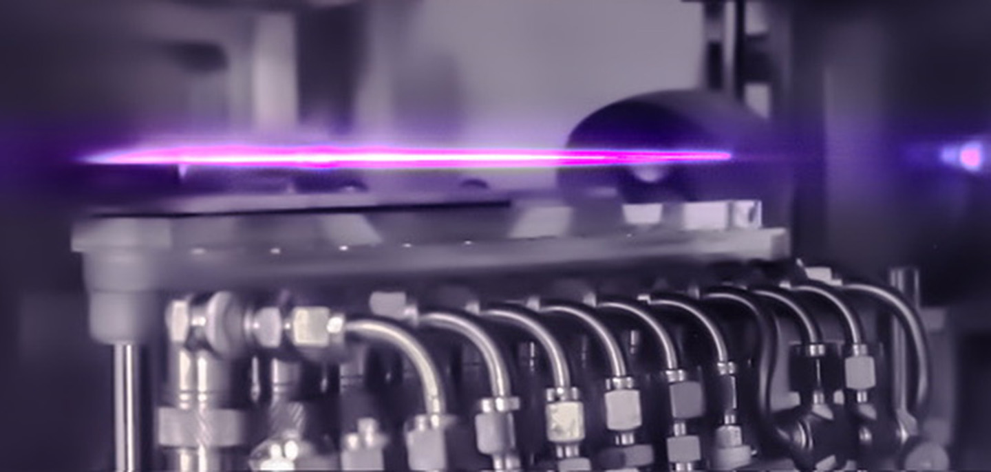 A thin purple beam appears suspended over a silver piece of equipment.