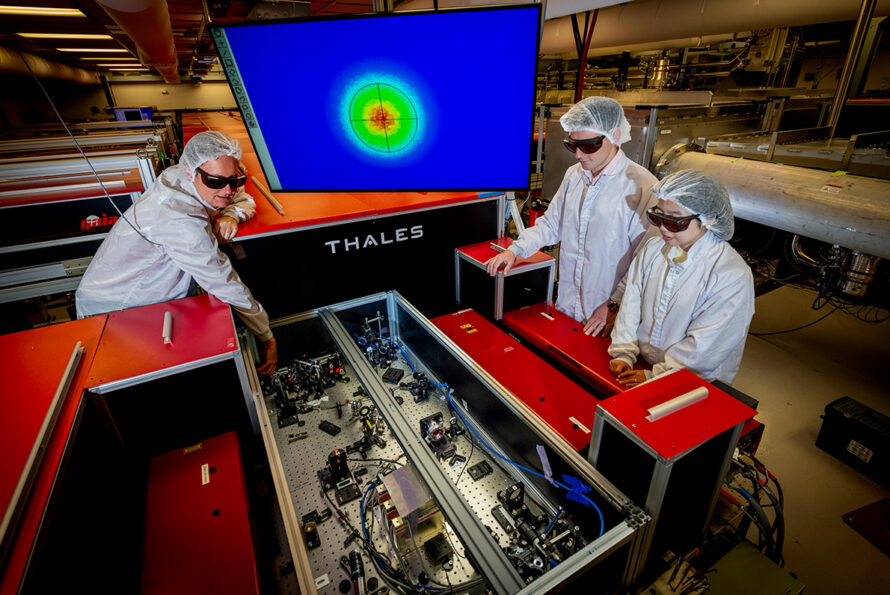 Three researchers align precision optics to prepare the Berkeley Lab Laser Accelerator (BELLA) Petawatt laser for laser-plasma accelerator experiments.