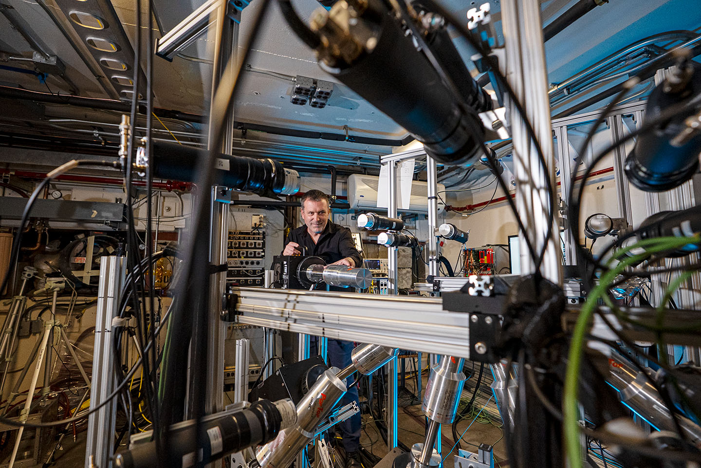 Mathis Wiedeking framed by gray experimental equipment and cords.