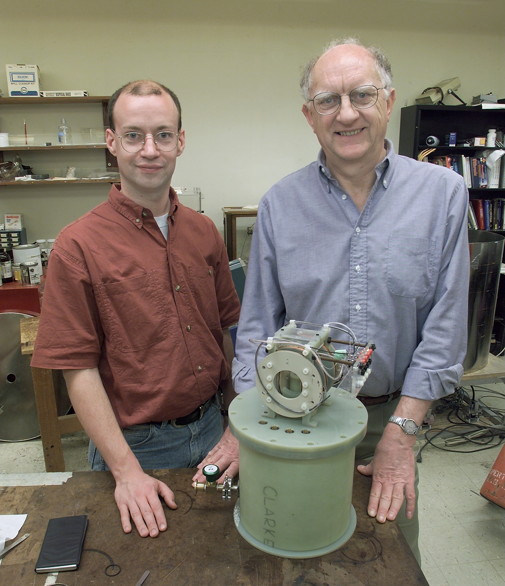 Two researchers stand behind a table with a SQUID detector sitting on top.