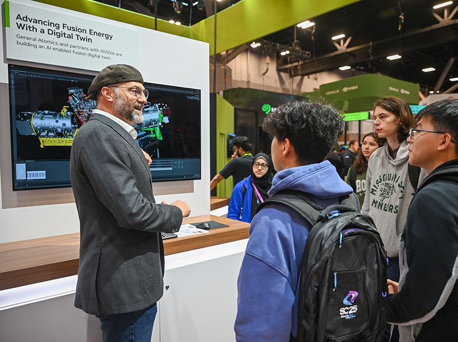 A researcher in a gray suit and beret speaks to students in a conference hall.