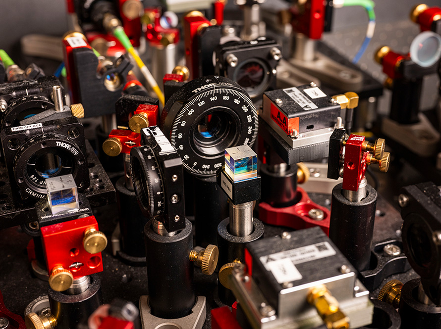A close-up view of an optical lens with various red, black, and metal details surrounding.