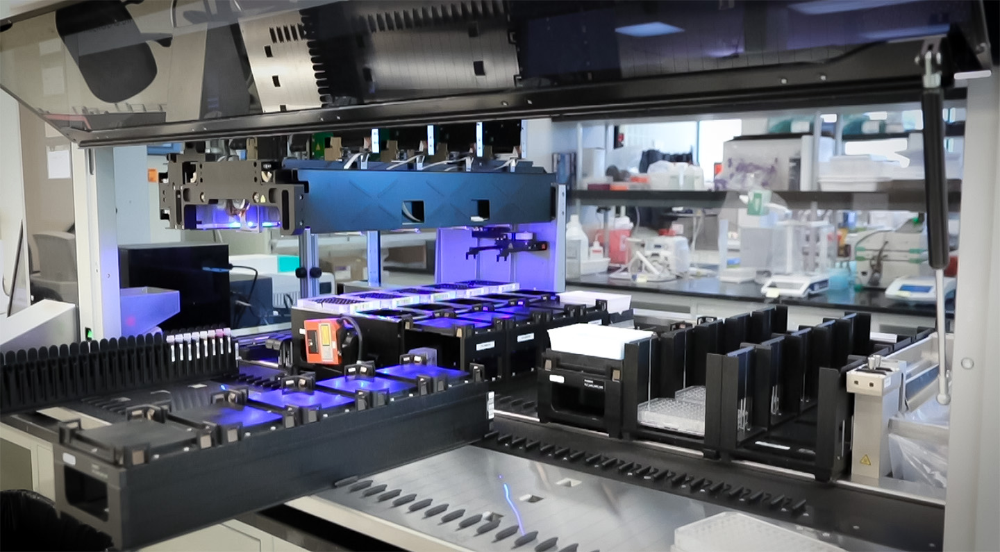 A laboratory space showing robotic liquid handling equipment.